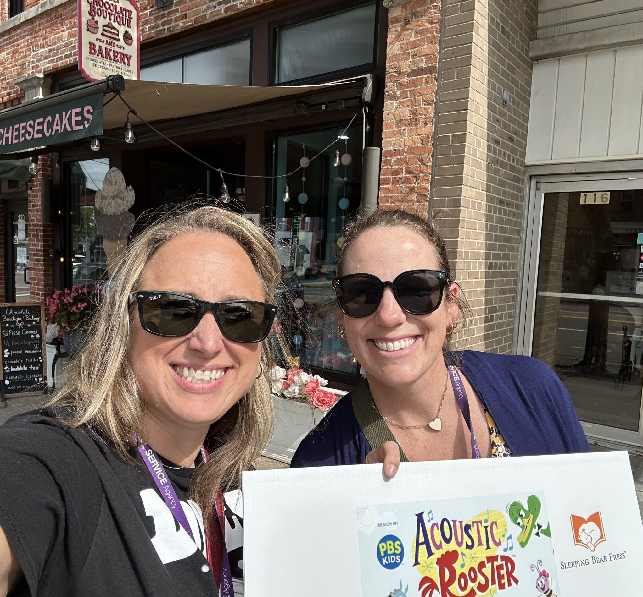 Great Start Livingston collecting an Acoustic Rooster StoryWalk page outside Chocolate Boutique and Bakery in downtown Howell